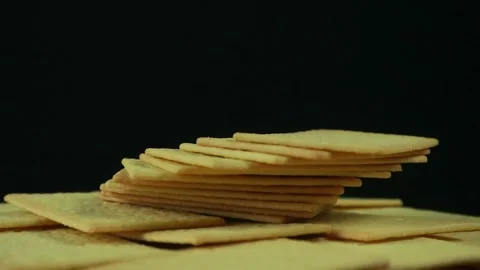 Stack of crispy salted crackers on black background. Rotating display 스톡 동영상 293780318