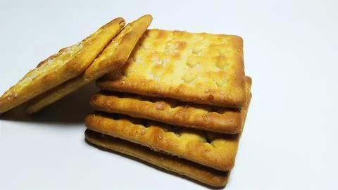 Stack of crispy square crackers on white background. Stock Photos