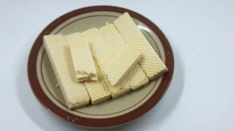 Stack of crispy vanilla wafer cookies arranged neatly on a brown ceramic plate Stock Footage 328162829