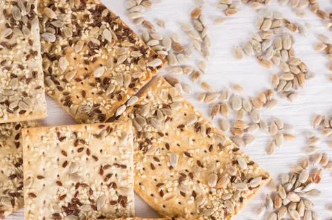 Stack of crispy wheat cakes with sesame, flax and sunflower seeds on white wo Stock Photos