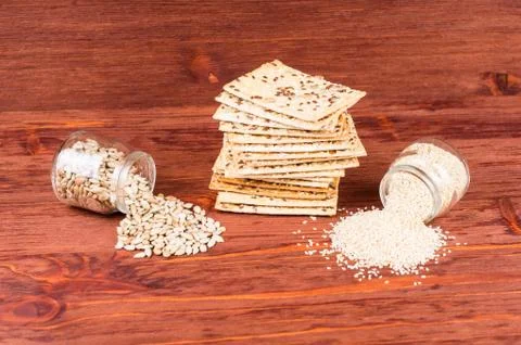 Stack of crispy wheat cakes with sesame seeds, flax and sunflower on a red wo Stock Photos