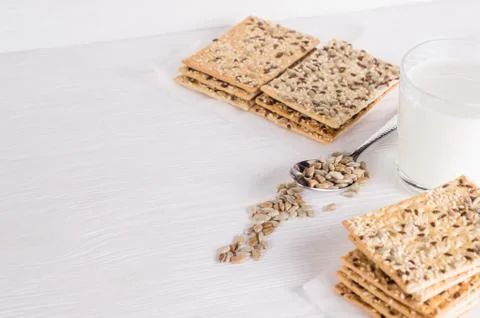 Stack of crispy wheat cakes with sesame seeds, flax and sunflower on a white Stock Photos