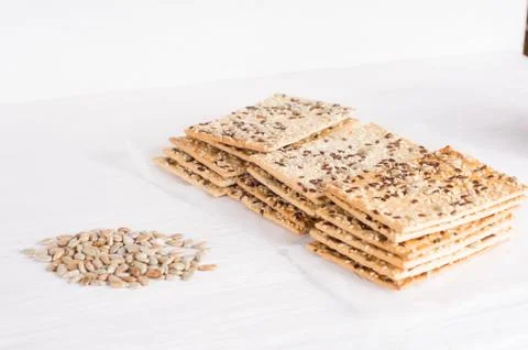 Stack of crispy wheat cakes with sesame seeds, flax and sunflower on a white Stock Photos
