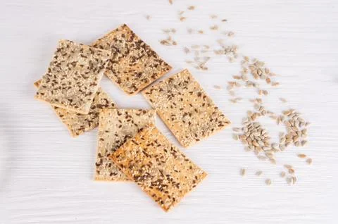 Stack of crispy wheat cakes with sesame, flax and sunflower seeds on white wo Stock Photos