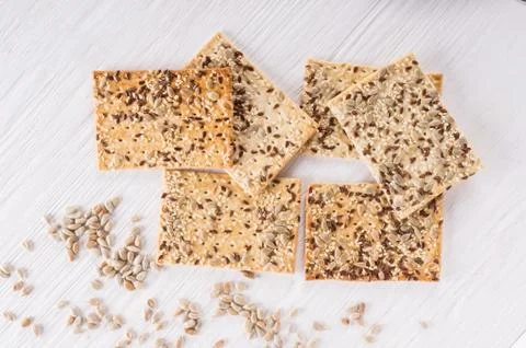 Stack of crispy wheat cakes with sesame, flax and sunflower seeds on white wo Stock Photos