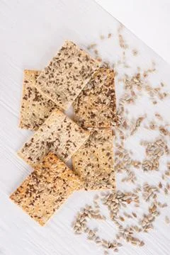 Stack of crispy wheat cakes with sesame, flax and sunflower seeds on white wo Stock Photos