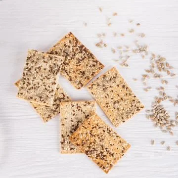 Stack of crispy wheat cakes with sesame, flax and sunflower seeds on white wo Stock Photos