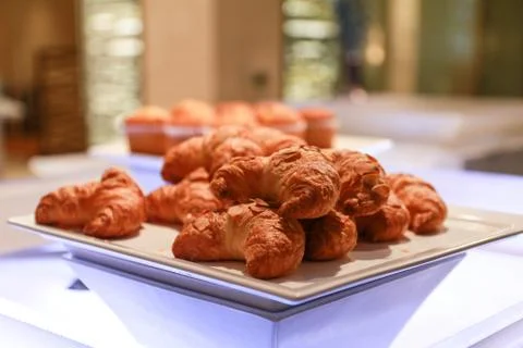 Stack of croissants in a hotel breakfast buffet on a white plate Stock Photos