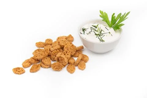 A stack of croutons breadcrumbs and a bowl of green onions and sour cream are Stock Photos