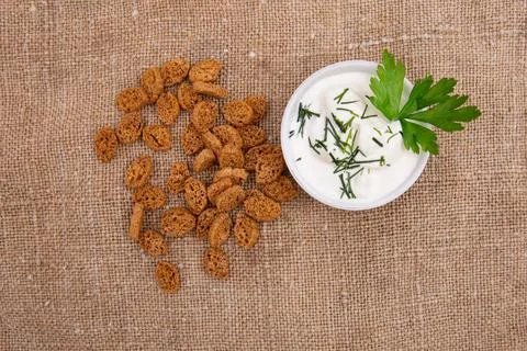 A stack of croutons breadcrumbs and a bowl of green onions and sour cream are Stock Photos