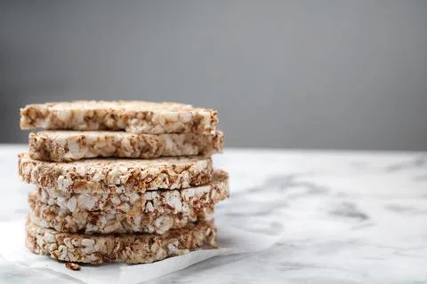 Stack of crunchy buckwheat cakes on white marble table, closeup. Space for te Foto stock