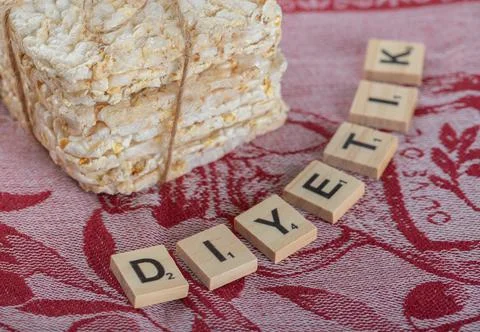 Stack of crusty crispbread and wooden letters on red cloth Stock Photos