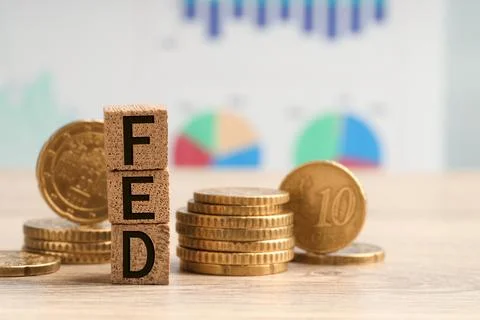 Stack of cubes with letters Fed (Federal Reserve System) and coins on woode.. Stockfoto's