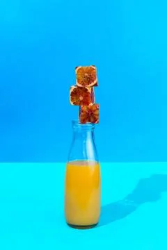 Stack of cubes made of red oranges on the glass bottle with citrus juice, sel 库存照片