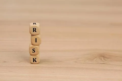 Stack of cubes with word Risk on wooden table. Space for text Stockfoto's