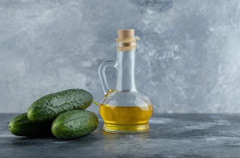 Stack of cucumber and bottle of oil Foto stock