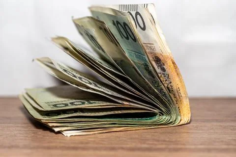 Stack of currency bills held together by an elastic band takes the shape of an o Stock Photos