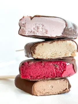 Stack of cut assorted chocolate ice cream bars with different flavors on white Foto stock