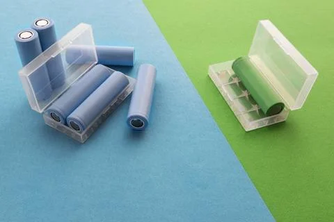 A stack of cylindrical 18650 batteries on a blue-green background Foto stock