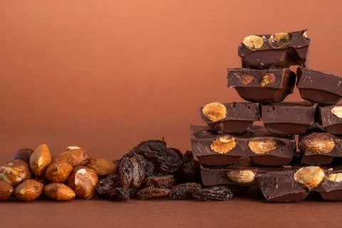 Stack of dark chocolate pieces with roasted almonds and raisins Stock Photos