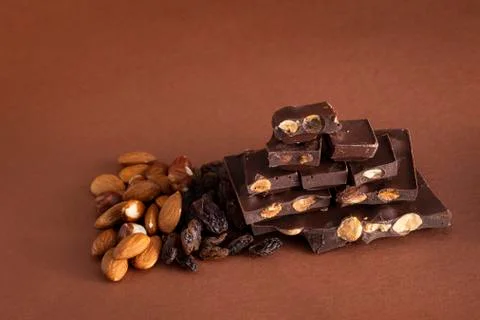 Stack of dark chocolate pieces with roasted almonds and raisins Stock Photos