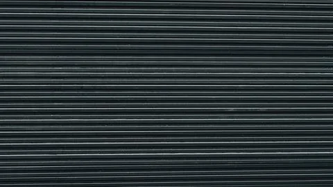 Stack of dark composite decking boards, focusing on the repetitive linear tex Stock Photos