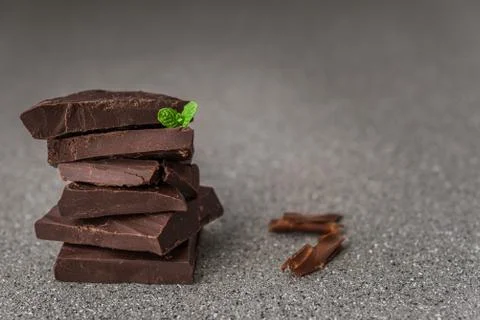 A stack of dark milk chocolate against gray stone background. Stock Photos