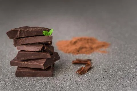 A stack of dark milk chocolate against gray stone background. Stock Photos