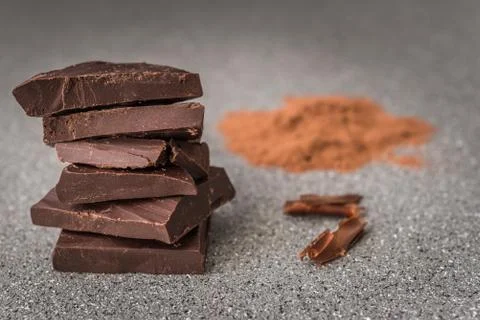 A stack of dark milk chocolate against gray stone background. Stock Photos