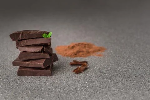 A stack of dark milk chocolate against gray stone background. Stock Photos