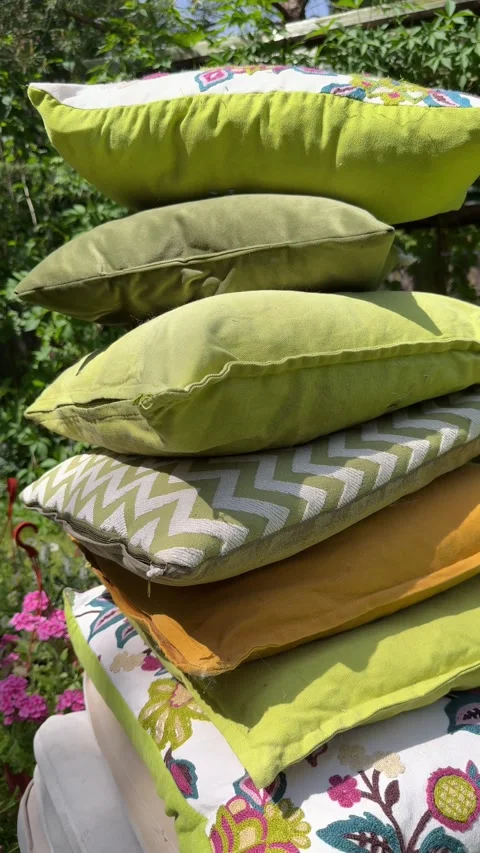 Stack of Decorative Outdoor Cushions on Garden Swing Under Green Pergola Video stock 336975712