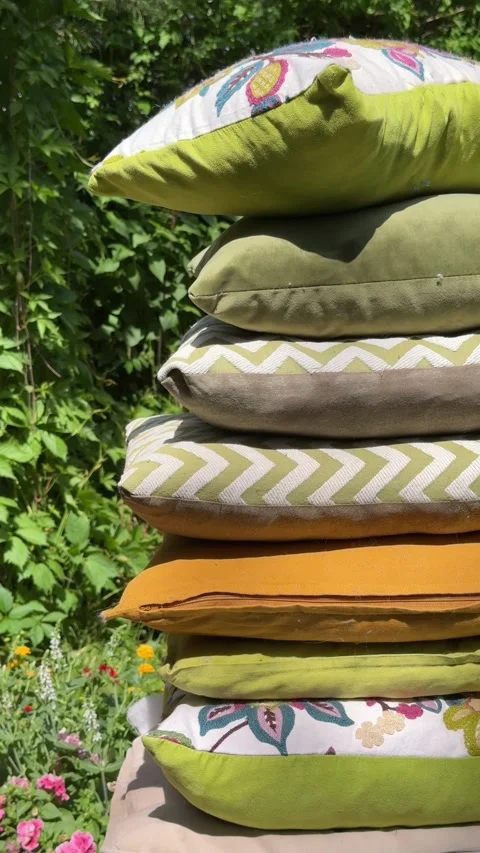 Stack of Decorative Outdoor Cushions on Garden Swing Under Green Pergola Video stock 336975721