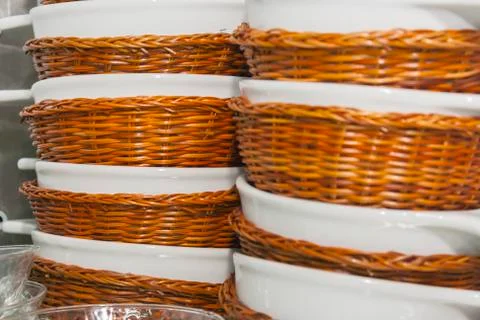 A stack of deep plates in wicker baskets 写真素材