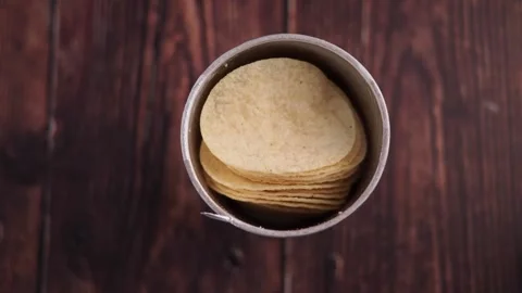 Stack of delicious and crispy potato chips in open can on dark wooden table. Stock Footage 332887462