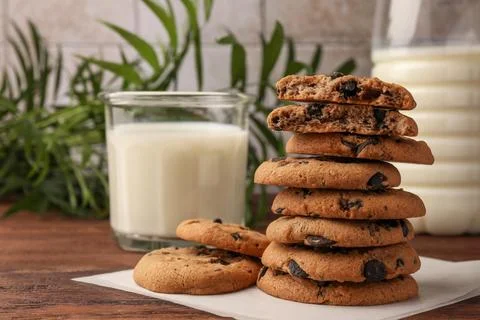 Stack of delicious chocolate chip cookies and milk on wooden table. Space f.. Stock Photos