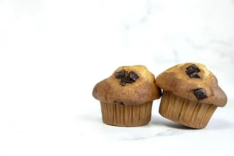 A stack of delicious chocolatechip banana muffins and blueberries on a white Stock Photos