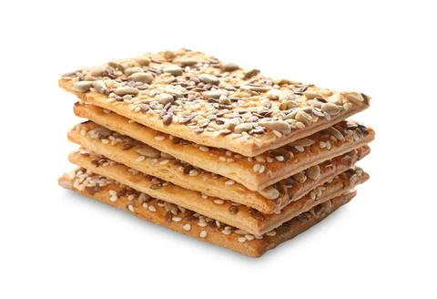 Stack of delicious crispy crackers with different seeds isolated on white Foto stock