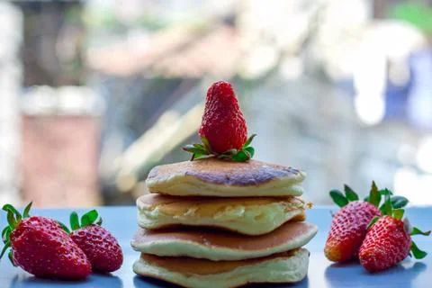 Stack of delicious fluffy pancakes with fresh strawberries and sugar and hone Stock Photos