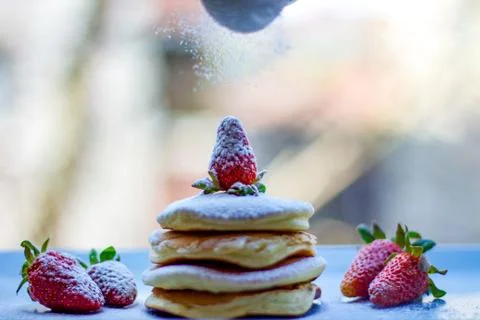 Stack of delicious fluffy pancakes with fresh strawberries and sugar and hone Stock Photos