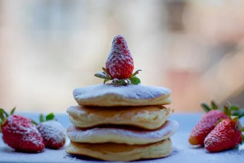 Stack of delicious fluffy pancakes with fresh strawberries and sugar and hone Stock Photos