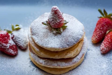 Stack of delicious fluffy pancakes with fresh strawberries and sugar and hone Stock Photos