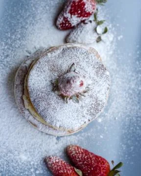 Stack of delicious fluffy pancakes with fresh strawberries and sugar and hone Stock Photos