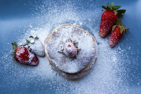 Stack of delicious fluffy pancakes with fresh strawberries and sugar and hone Stock Photos