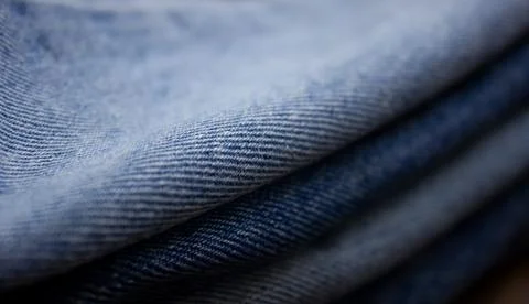 A stack of denim. Color denim close-up texture. Stock Photos