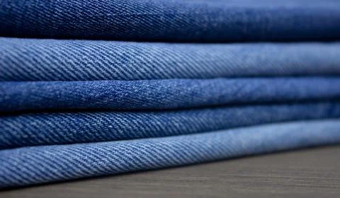 A stack of denim. Color denim close-up texture. Stock Photos