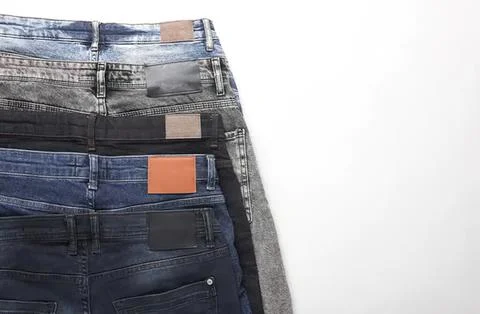 Stack of denim jeans in different shades on a white background Stockfoto's
