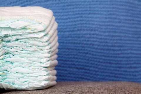 Stack of diapers or nappies on blue knitted background Stock Photos