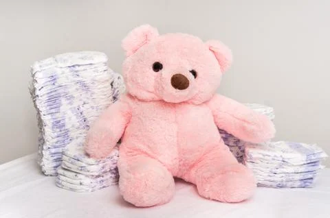 Stack of diapers or nappies with pink teddy bear - hygiene concept Stock Photos