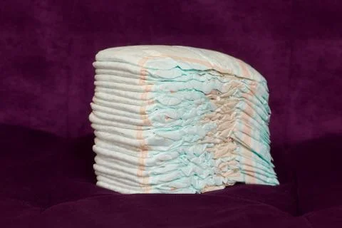 Stack of diapers or nappies on purple background Stock Photos