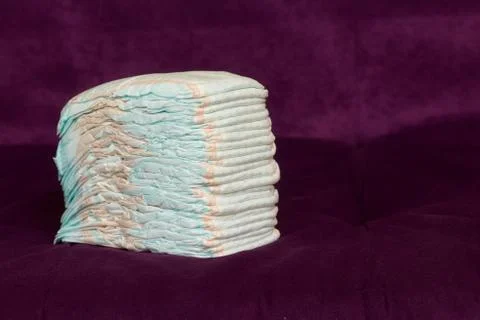 Stack of diapers or nappies on purple background Stock Photos